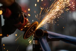 Worker,Cutting,,Grinding,And,Polishing,Motorcycle,Metal,Part,With,Sparks