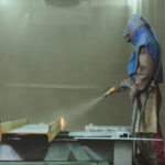 An,Employee,Prepares,A,Metal,Part,For,Painting.,A,Harsh