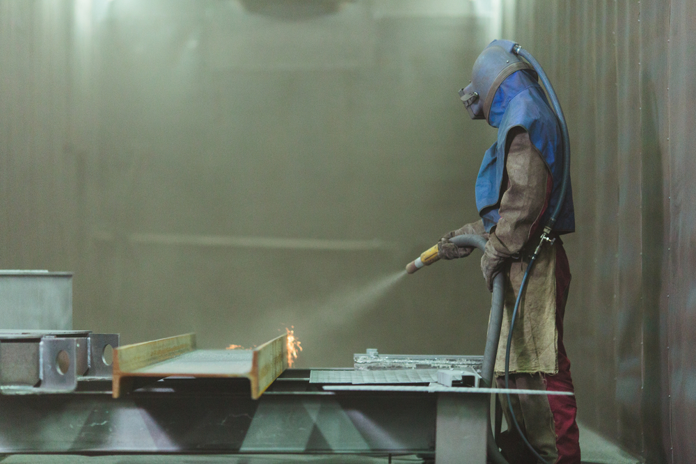 An,Employee,Prepares,A,Metal,Part,For,Painting.,A,Harsh